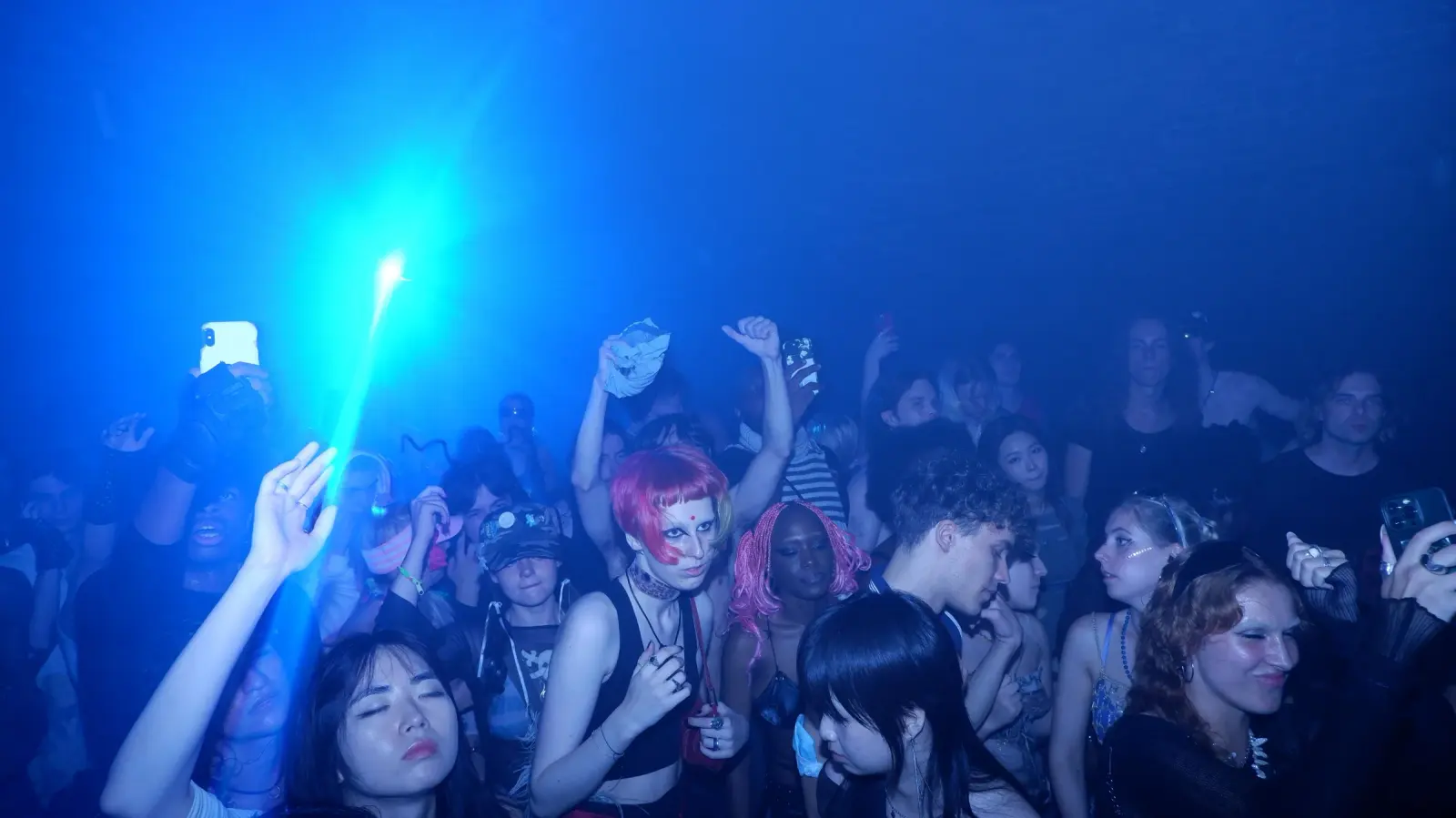 A Genesys crowd, hands up under the blue light
