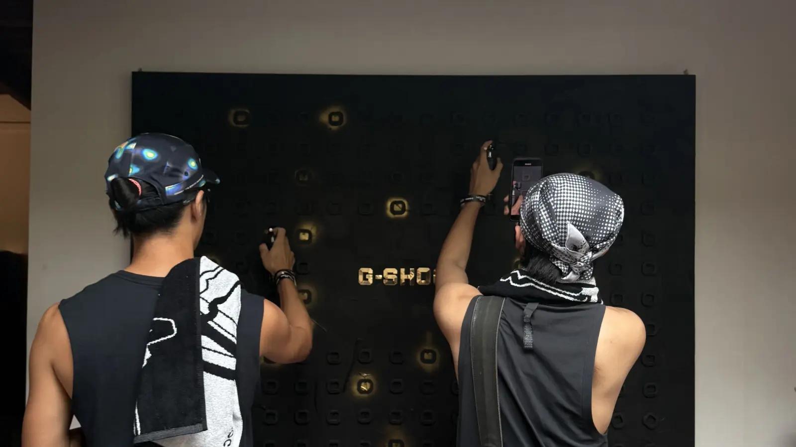 Two guests tapping the tags on the G-SHOCK wall